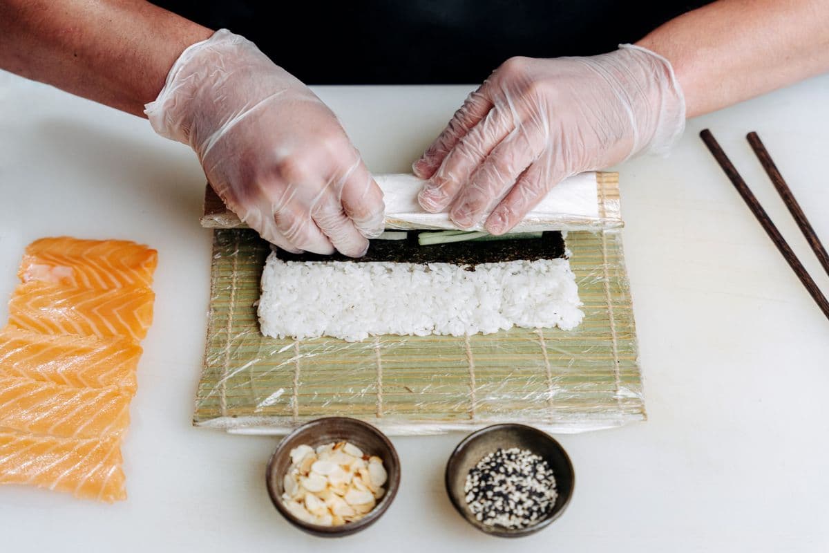 Šéfkuchár Kenji formuje nigiri pri výdajnom pulte.